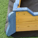 Wooden boat sandbox corner with blue and yellow panels on artificial grass