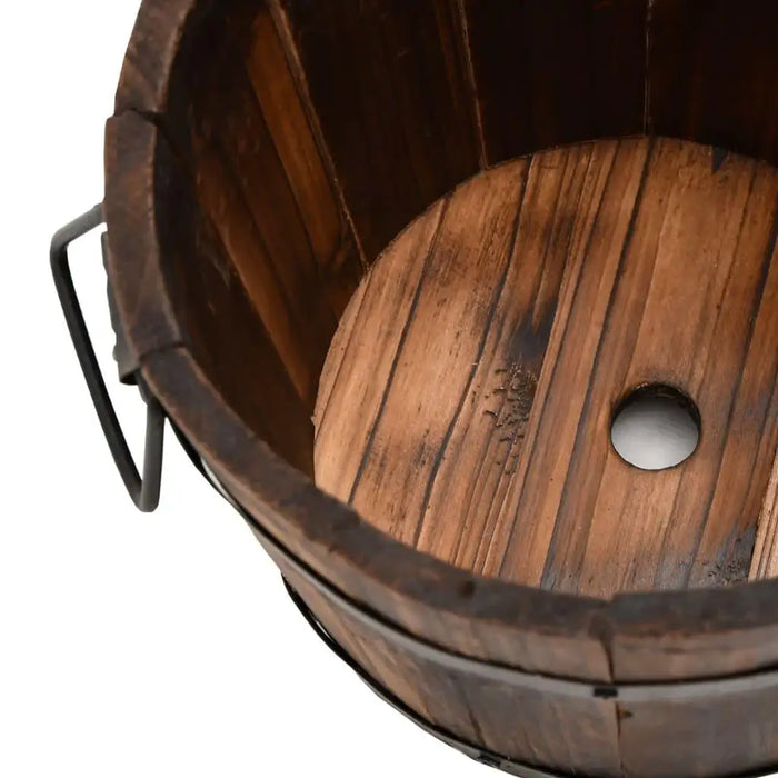 Close-up of wooden bucket planter with burned finish, drainage hole, and metal handle