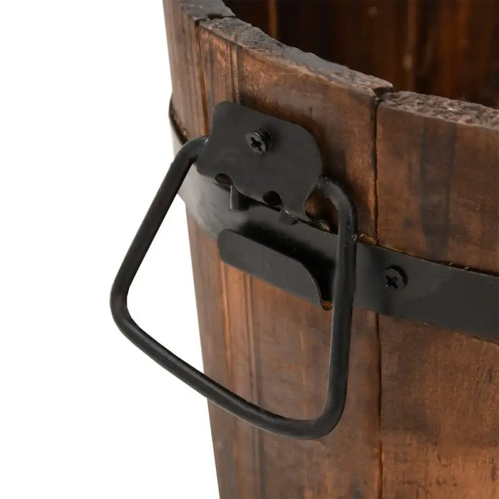 Close-up of a wooden bucket planter with metal handle and burned finish