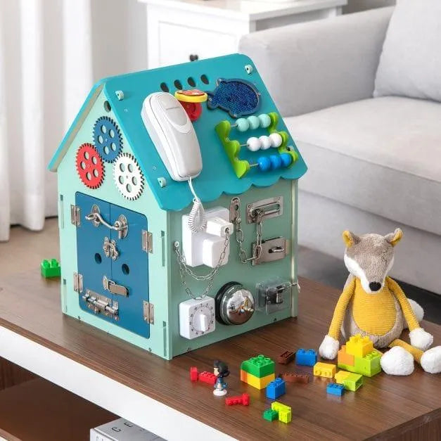 Wooden busy house early learning toy with gears, locks, and abacus on a coffee table