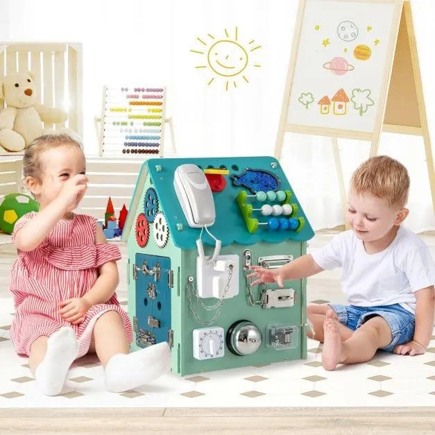 Two toddlers playing with a blue wooden busy house early learning activity toy indoors