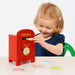 Child playing with a toy post box on a light background