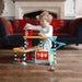 Child playing with Vilac wooden three-level toy garage and vehicle playset on wooden floor
