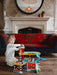 Child playing with wooden three-level toy garage and car playset in cozy living room