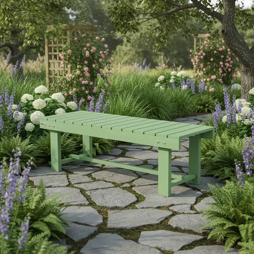 Light green wooden garden bench on stone pathway surrounded by lush green plants and colorful flowers