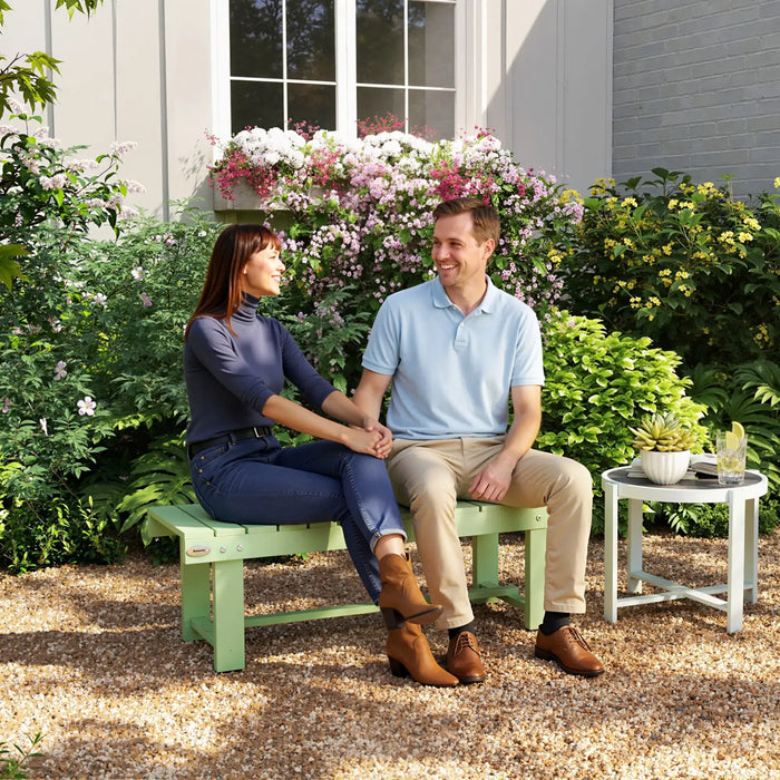 Couple sitting on light green wooden outdoor garden bench surrounded by colorful flowers and plants
