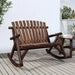 Wooden garden rocking bench in Adirondack style on a deck beside a side table and plants