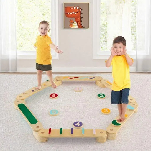 Two kids playing on a wooden Montessori balance beam set with stepping stones indoors.