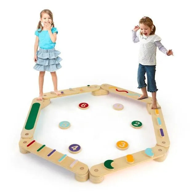 Two children playing on a wooden Montessori balance beam set with stepping stones.
