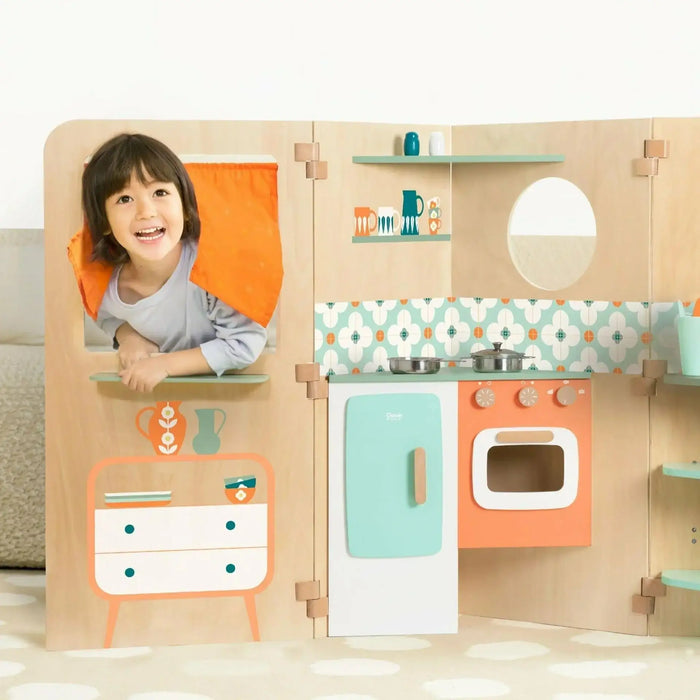 Child playing in wooden foldable playhouse kitchen with colorful retro design