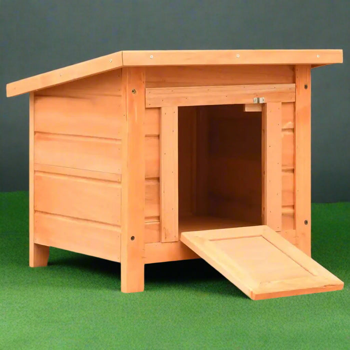 Wooden outdoor cat house with ramp, brown weather-resistant shelter on green grass