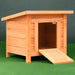 Wooden outdoor cat house with ramp, brown weather-resistant shelter on green grass