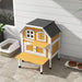 Yellow wooden outdoor cat house with terrace and jump platform on patio