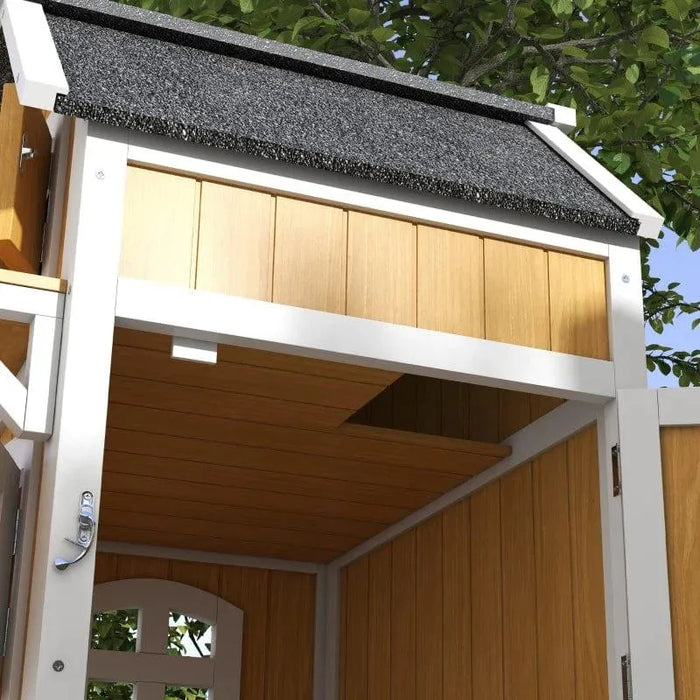Wooden outdoor cat house with yellow siding, black roof, and two-tier shelter under a tree.
