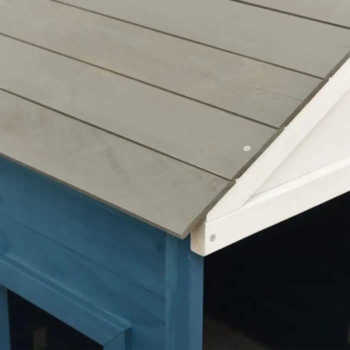 Close-up of blue and grey wooden playhouse roof with white trim outdoors