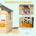Wooden outdoor playhouse with bench, serving station, and flowerpot holder.
