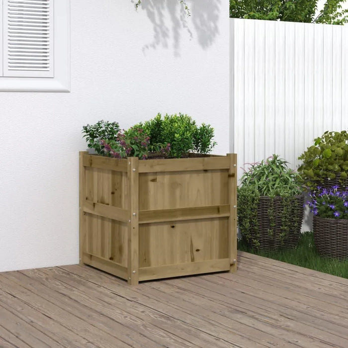 Wooden planter box with green plants on deck beside white wall and fence