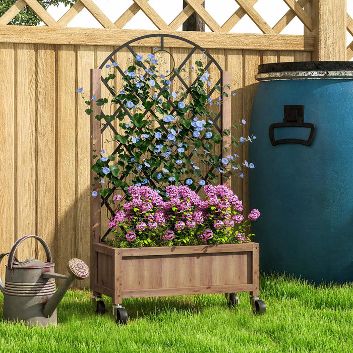 Wooden planter with diamond-shaped trellis on wheels holding blooming blue and pink flowers on grass