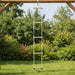 Wooden rope ladder with five rungs hanging outdoors on playground frame, green grass below