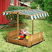 Child playing in wooden sandbox with benches and adjustable canopy in a backyard