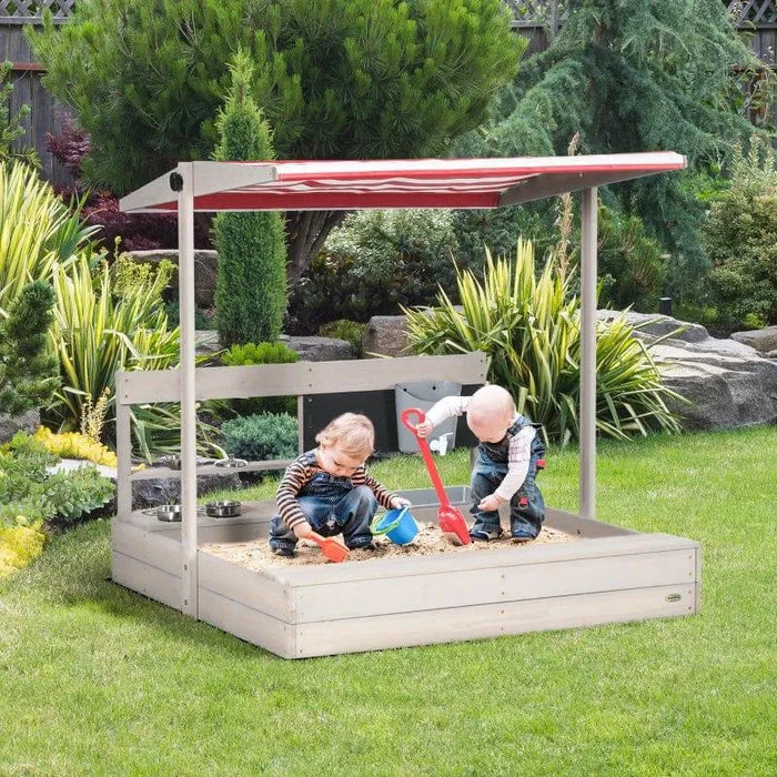 Kids playing in wooden sandbox with play kitchen and adjustable canopy outdoors