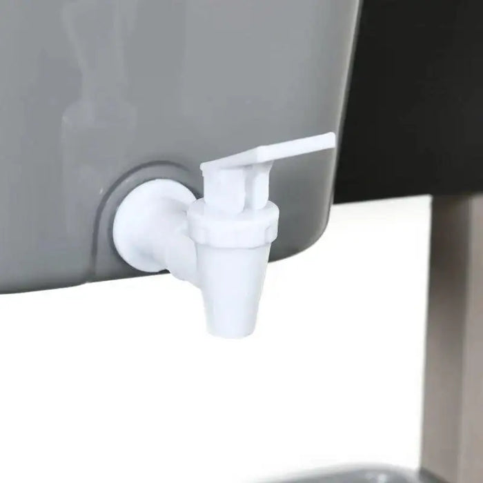 Close-up of white plastic faucet attached to a grey container on play kitchen set