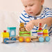 Toddler playing with wooden stackable train set, animal blocks, and educational toys