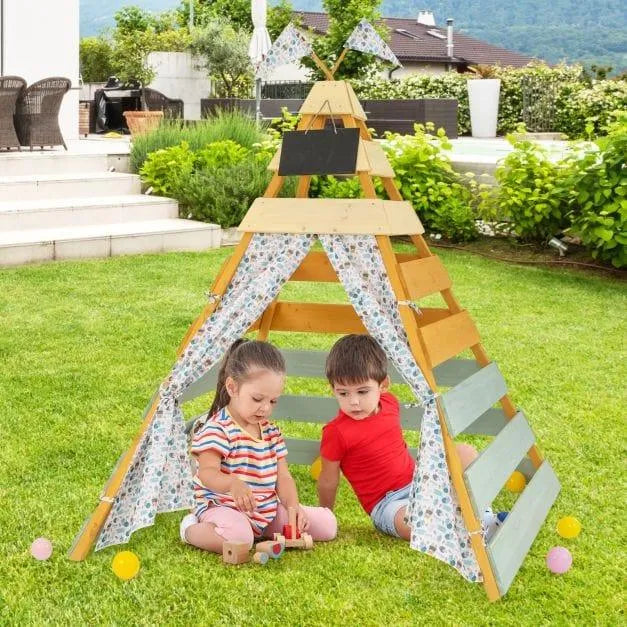 Children playing in a wooden Montessori teepee tent on grass in a backyard garden