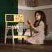 Young girl playing with wooden tool bench carpentry playset indoors