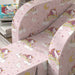 Pink children's armchair with unicorn, rainbow, cloud, star, moon, and castle pattern upholstery