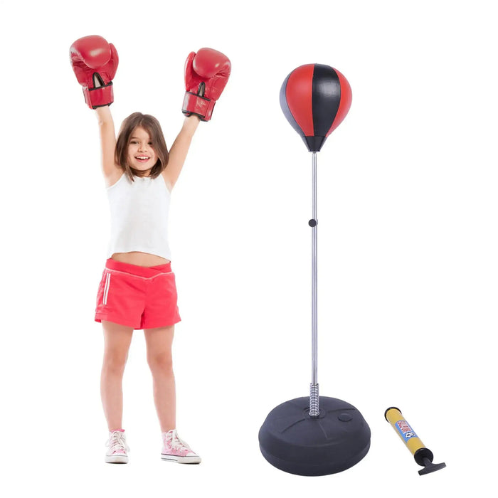 Young girl in red boxing gloves and shorts next to inflatable punching bag with hand pump