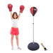Young girl in red boxing gloves and shorts next to inflatable punching bag with hand pump