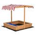 Yellow wooden sandbox with red and white canopy and blue storage bins