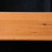 Close-up of smooth yellow wooden plank with visible grain and knot detail.