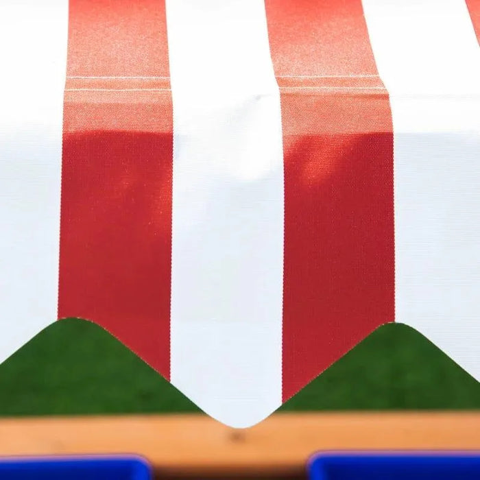 Red and white striped adjustable canopy on yellow wooden sandbox outdoors