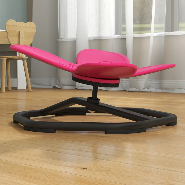 Pink and black ergonomic chair on a wooden floor with a neutral background