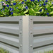 Metal raised garden bed corner with vibrant green leaves and blue flowers inside