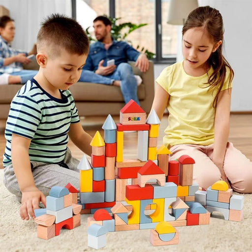 Kids building a colorful wooden block castle set on a carpeted floor indoors