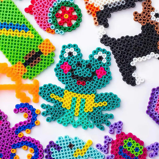 Colorful animal and shape designs made from iron fuse beads on a white background