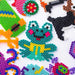 Colorful animal and shape designs made from iron fuse beads on a white background