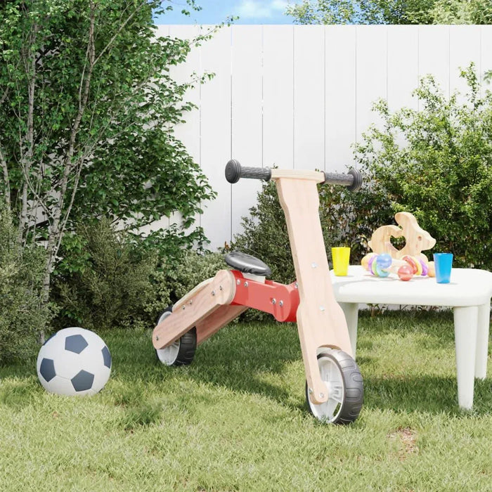 2-in-1 kids scooter and balance bike in red and black on grass with toys and a soccer ball