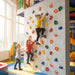 Kids climbing indoor play wall with multicolor climbing holds in playroom
