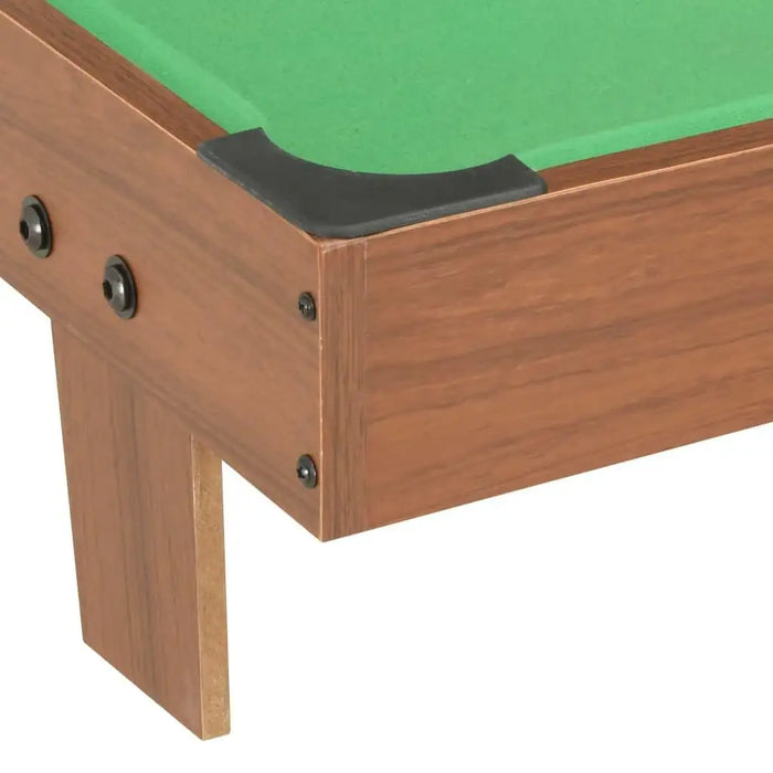 Close-up of brown wooden tabletop pool table with green felt surface and black corner