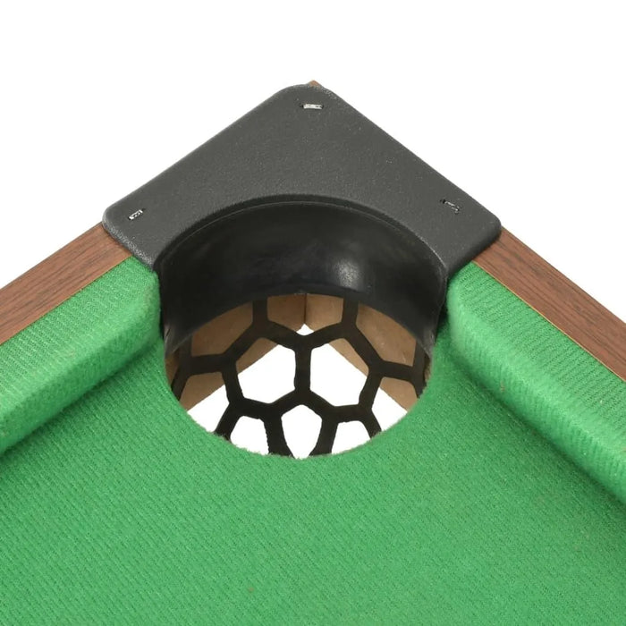Close-up of 3ft tabletop pool table corner pocket with green felt and wood trim.