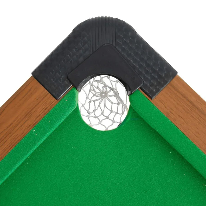 Corner pocket of a green portable billiard table with wood trim and netted pocket.