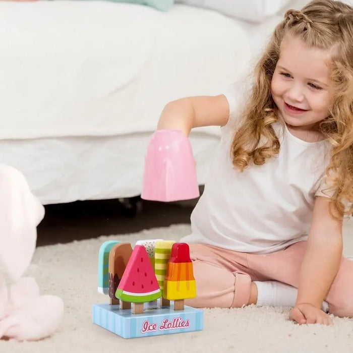 Smiling girl playing with colorful wooden ice cream lollies pretend playset on carpet