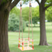 Solid pinewood baby swing with red and yellow beads hanging from a tree in a park