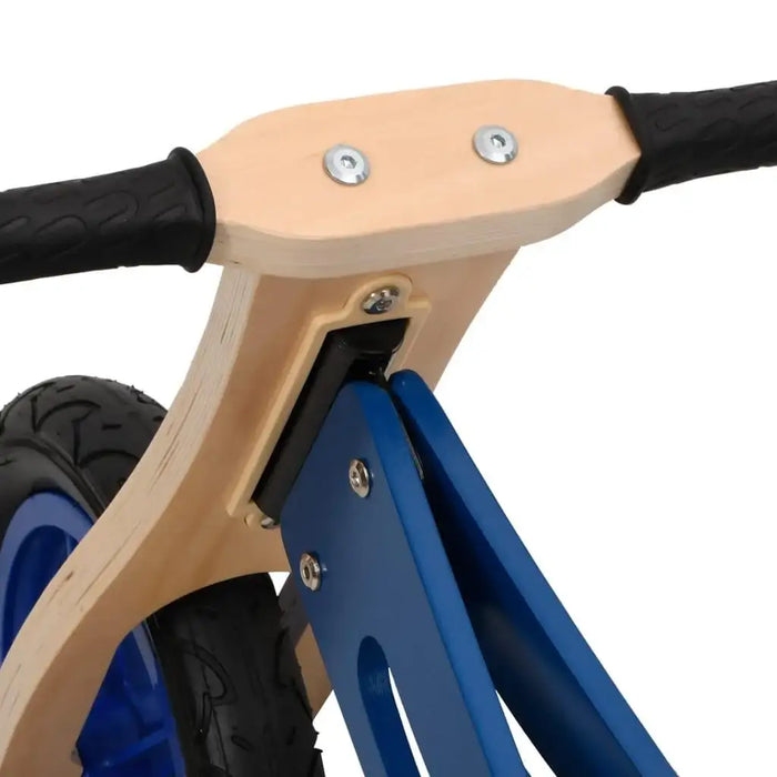 Close-up of blue and black balance bike with plywood frame, adjustable handlebar and seat