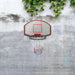 Wall-mounted basketball backboard set with steel rim and net on concrete wall, outdoor setting