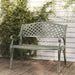Cast aluminium garden bench with lattice backrest on wooden deck, green foliage in background